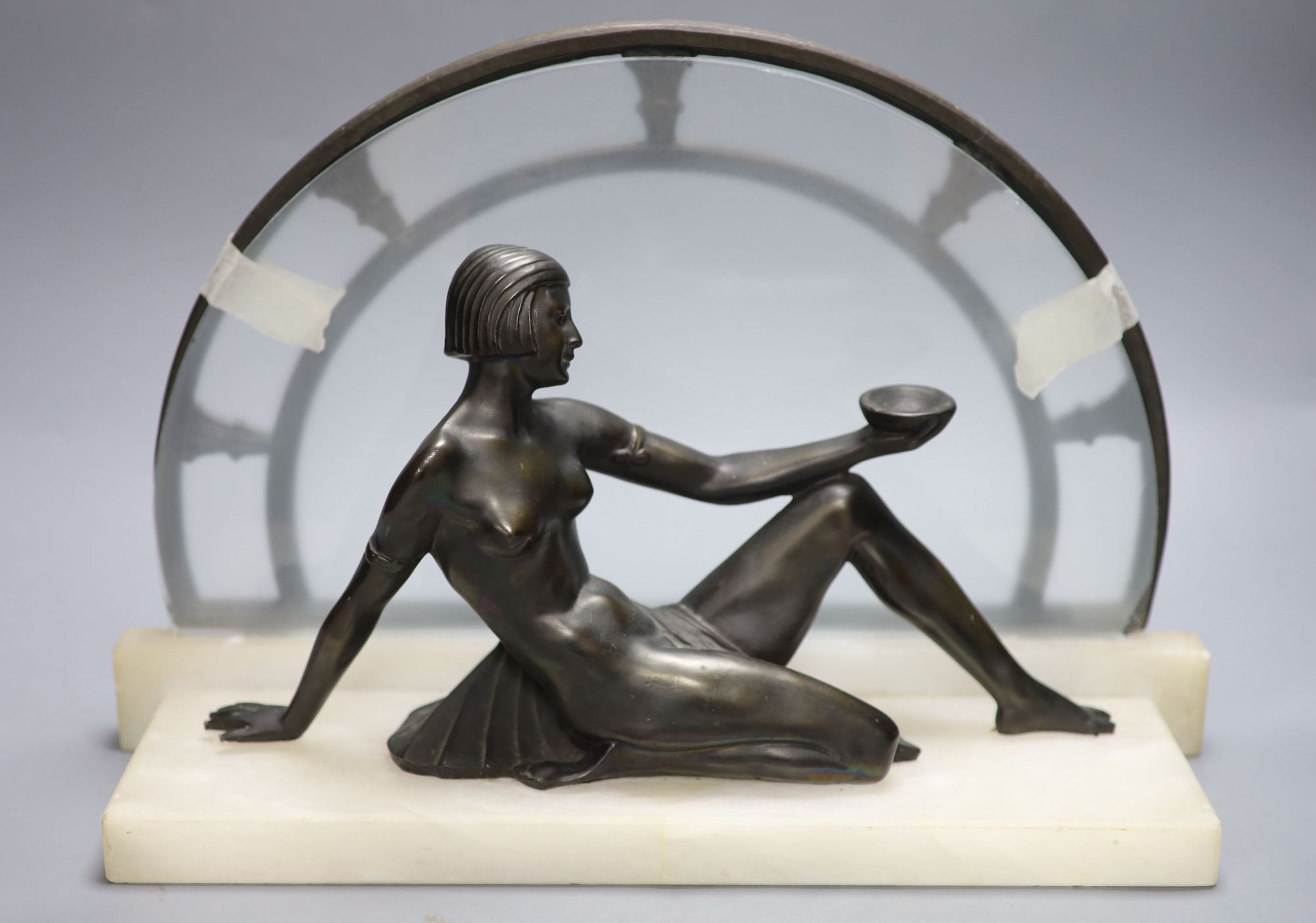 An Art Deco style bronze of nude reclining female figure on white marble plinth, length 42cm